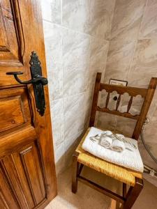 a bathroom with a wooden door and a chair at Casa Rural Nueva Araceli in Oliete +34 photos