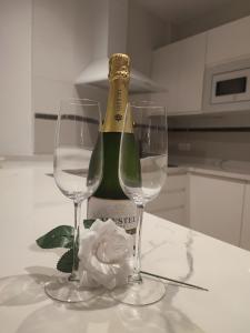 una bottiglia di champagne e due bicchieri di vino su un tavolo di Wonder Atic, with private terraces, jacuzzi and stunning views a Cómpeta