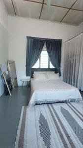 a bedroom with a large bed and a window at Homestay Laman Dahlia in Kuala Kangsar