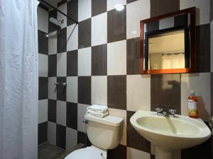 La salle de bains est pourvue d'un lavabo, de toilettes et d'un miroir. dans l'établissement Ilusión apartment 2 bedroom 1 bathroom, à Baños