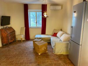 ein Wohnzimmer mit einem Sofa und einem Kühlschrank in der Unterkunft Seele baumeln lassen im Olivenhain (Meeresnähe) in Santa Caterina dello Ionio