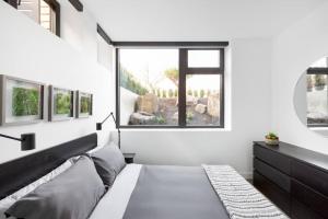 Designer 2 Bdr Garden Suite - Arbutus, Kits & UBC في فانكوفر: غرفة نوم بسرير ونافذة