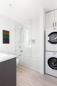 a white bathroom with a washing machine and a sink at Designer 2 Bdr Garden Suite - Arbutus, Kits & UBC in Vancouver