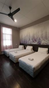 a room with three beds and a painting on the wall at Jabez Resort Kundasang in Kundasang