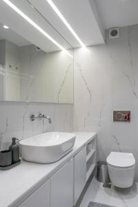uma casa de banho branca com um lavatório e um WC em Mayer Hellas 2Br Duplex Kolonaki Apartment em Atenas
