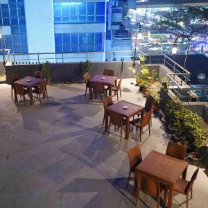 a row of tables and chairs on a rooftop patio at Hotel Fountain Luxury In Comfort in Dhaka