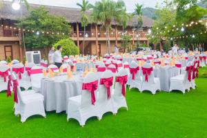 un gruppo di tavole con fiocchi rossi e bianchi di Hoa Binh Hotel a Hòa Bình