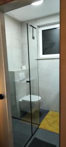 a bathroom with a toilet through a glass door at POMODORO ROOMS in Zagreb
