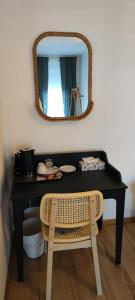 a black desk with a mirror and a chair at POMODORO ROOMS in Zagreb