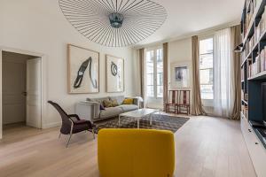 a living room with a yellow couch and a yellow chair at Veeve - Square du Temple Comfort in Paris