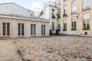 an empty courtyard in front of a building at Veeve - Square du Temple Comfort in Paris