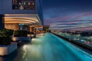 uma piscina no meio de um edifício à noite em Holiday Inn & Suites Rayong City Centre, an IHG Hotel em Rayong