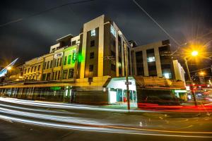 uma rua da cidade com um edifício à noite com faixas de luzes em Haka House Wellington em Wellington