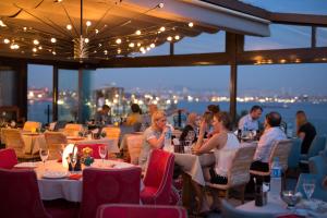 eine Gruppe von Personen, die in einem Restaurant an Tischen sitzen in der Unterkunft Tria Elegance Istanbul in Istanbul