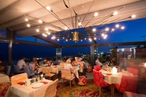 ein Restaurant mit Leuten, die an Tischen auf dem Dach sitzen in der Unterkunft Tria Elegance Istanbul in Istanbul