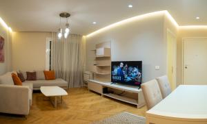 uma sala de estar com um sofá e uma televisão em Center Tirana Liv apartment em Tirana