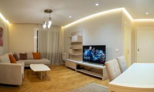 a living room with a couch and a tv at Center Tirana Liv apartment in Tirana