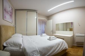 a bedroom with a white bed and a sink at Center Tirana Liv apartment in Tirana