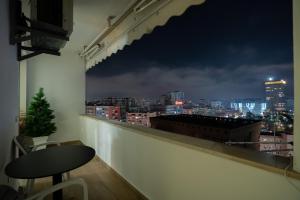 a balcony with a view of a city at night at Center Tirana Liv apartment in Tirana