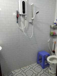 Happy Family Guesthouse في فينه لونج: حمام مع دش مع كرسي أزرق ومرحاض