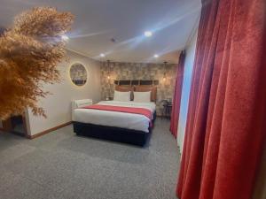 1 dormitorio con 1 cama grande y cortinas rojas en TownHouse Tbilisi Boutique Hotel, en Tiflis