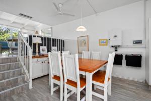 een eetkamer met een houten tafel en witte stoelen bij San Lameer Villa 3008 - 4 Bedroom Classic - 8 pax - San Lameer Rental Agency in Southbroom