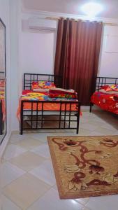 um quarto com 2 camas individuais e um tapete em Studio em Hurghada