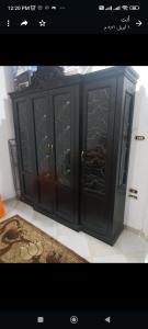 um armário preto com portas de vidro num quarto em Studio em Hurghada