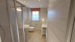ein Badezimmer mit Toilette und Waschbecken und einem Fenster in der Unterkunft Ferienwohnung Gartentraum mit tollem Rasengarten in Ostseebad Karlshagen + 28 Fotos