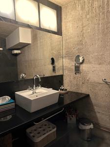 y baño con lavabo blanco y espejo. en Loft Rural LaCalata, en Calatañazor