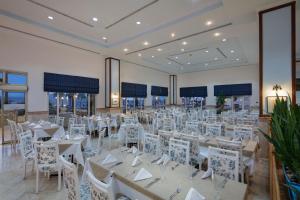 un salón de banquetes con mesas blancas y sillas blancas en Selectum Colours Bodrum, en Gümbet