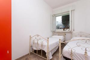 Duas camas num quarto branco com uma janela em Trilocale vicino al mare a Numana - N129 em Marcelli