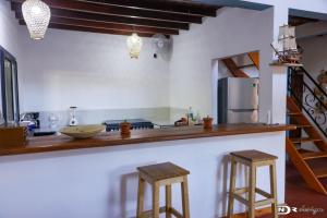 a kitchen with a counter with stools and a refrigerator at tsarajoro in Mahajanga