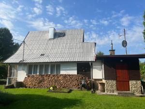 a white house with a stone wall next to it at YURA vila Čeladná - ZDARMA SAUNA A VNITŘNÍ BAZÉN V YURA HOTELU in Čeladná