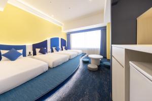 a row of beds in a hotel room at Hotel Keihan Universal Tower in Osaka