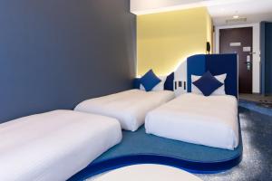 two beds in a room with blue and white at Hotel Keihan Universal Tower in Osaka