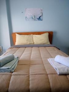 Argiris Old City House 2 في كالامباكا: غرفة نوم بسرير كبير عليها منشفتين