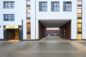 a white building with a garage with a parking lot at master Altona in Hamburg