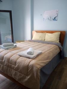 duże łóżko z dwoma ręcznikami na górze w obiekcie Argiris Old City House 2 w Kalambace