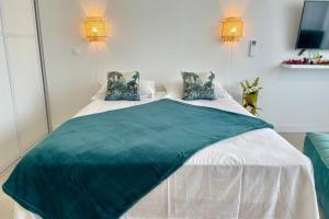 a bedroom with a large bed with a green blanket on it at Studio Hanalei City brand new in the center of Papeete WiFi -Netflix -AC in Papeete