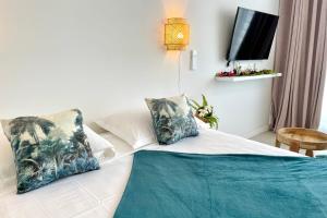 a bedroom with a bed with a tv on the wall at Studio Hanalei City brand new in the center of Papeete WiFi -Netflix -AC in Papeete