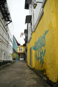 an alley with graffiti on the side of a yellow building at City View Hostel in Kandy