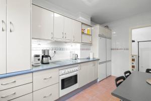 cocina blanca con armarios blancos y mesa en Cozy rooftop in Torreblanca - Ref 27, en Fuengirola