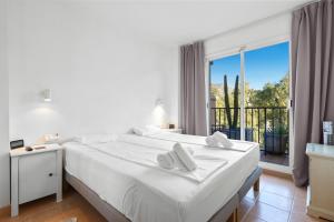 Dormitorio blanco con cama y ventana grande en Cozy rooftop in Torreblanca - Ref 27, en Fuengirola
