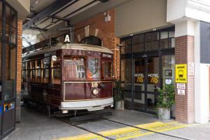 a trolley car is parked outside of a building at Hotel 115 in Christchurch