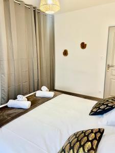 a bedroom with two beds with towels on them at La Douceur de l'Allier, proche gare, avec services premium, by PRIMO C0NCIERGERIE in Moulins