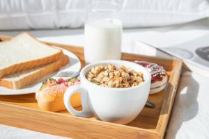 a tray with a cup of cereal and a plate of doughnuts at Doubletree By Hilton Suzhou Wujiang in Suzhou