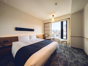 高山的住宿－Tokyu Stay Hida Takayama Musubinoyu，一间卧室设有一张大床和一个大窗户