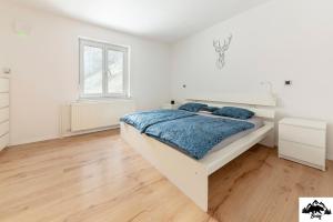 een witte slaapkamer met een bed en een raam bij Brlog in Zgornje Gorje