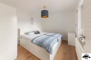 a white bedroom with a bed in a white room at Brlog in Zgornje Gorje